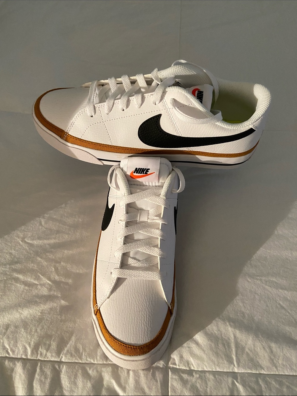 Nike Women’s White Sneakers with Black Swoosh and Gold Trim